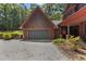 A detached garage with a gray door sits near a home with cedar shake siding and landscaped accents at 4110 Stoneycreek Rd, Chapel Hill, NC 27514