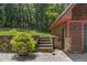 A detached garage features stone accents, wood siding, and a stairway leading to an upper lawn at 4110 Stoneycreek Rd, Chapel Hill, NC 27514