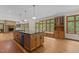 Spacious kitchen with a large island, stone fireplace, and ample natural light, perfect for cooking and gathering at 4110 Stoneycreek Rd, Chapel Hill, NC 27514
