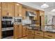 Modern kitchen featuring stainless steel appliances, wooden cabinets, and granite countertops, providing style and functionality at 4110 Stoneycreek Rd, Chapel Hill, NC 27514