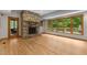Living room with a stone fireplace and large windows with wooded views at 4110 Stoneycreek Rd, Chapel Hill, NC 27514