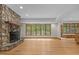Spacious living room with a stone fireplace and large windows with wooded views at 4110 Stoneycreek Rd, Chapel Hill, NC 27514