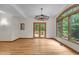 Bright living room features hardwood floors, a wagon wheel chandelier, and a large picture window overlooking the yard at 4110 Stoneycreek Rd, Chapel Hill, NC 27514