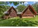 Exterior view of a home featuring wood siding, a well-maintained lawn, and mature trees at 4110 Stoneycreek Rd, Chapel Hill, NC 27514