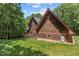 Exterior view of a home featuring wood siding, a well-maintained lawn, and mature trees at 4110 Stoneycreek Rd, Chapel Hill, NC 27514