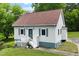 Charming home with light gray siding, a red roof, and vibrant landscaping, showcasing curb appeal at 524 N Occoneechee St, Hillsborough, NC 27278