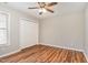 A bright bedroom with a ceiling fan, hardwood floors, window, and closet at 5437 Advantis Dr, Raleigh, NC 27610