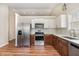 Modern kitchen featuring stainless steel appliances, white cabinets, stylish backsplash, and hardwood floors at 5437 Advantis Dr, Raleigh, NC 27610