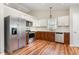 Modern kitchen featuring stainless steel appliances, white cabinets, stylish backsplash, and hardwood floors at 5437 Advantis Dr, Raleigh, NC 27610