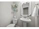 Powder room features pedestal sink, decorative mirror, and white toilet at 633 Copper Beech Ln, Wake Forest, NC 27587