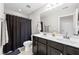 Classic bathroom featuring a dual sink vanity, a mirror, and a shower with a dark curtain at 633 Copper Beech Ln, Wake Forest, NC 27587