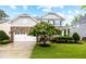 Beautiful home with a blooming tree and a stone accent garage, creating a striking and inviting exterior at 633 Copper Beech Ln, Wake Forest, NC 27587