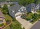 Aerial shot of a two-story home with a stone-accented garage, a well-kept lawn, and mature landscaping at 633 Copper Beech Ln, Wake Forest, NC 27587