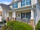 Inviting front porch with stone pillars, a cozy seating area, and charming decor, perfect for relaxing outdoors at 633 Copper Beech Ln, Wake Forest, NC 27587