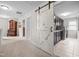 Hallway leading to a laundry room, with a sliding barn door and classic furniture at 633 Copper Beech Ln, Wake Forest, NC 27587