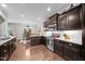 Beautiful kitchen with granite countertops, dark wood cabinetry, stainless steel appliances and a view into the dining area at 633 Copper Beech Ln, Wake Forest, NC 27587