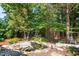Landscaped backyard with a stone-lined pond and a charming wooden cabin retreat nestled among the trees at 648 Long Melford Dr, Rolesville, NC 27571