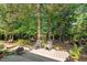 Serene backyard deck with cozy seating surrounded by lush greenery and a tranquil pond feature at 648 Long Melford Dr, Rolesville, NC 27571