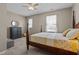 Bedroom featuring large windows with white curtains, a dark dresser and a matching four post bed at 648 Long Melford Dr, Rolesville, NC 27571