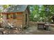 Charming cabin with rustic wood siding and a metal roof, set in a wooded area with outdoor seating at 648 Long Melford Dr, Rolesville, NC 27571
