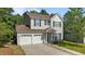 Charming two-story home with a well-manicured lawn, two-car garage, and inviting front porch at 648 Long Melford Dr, Rolesville, NC 27571