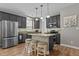 Open kitchen boasts an island with seating, stainless appliances, and stylish gray cabinetry at 648 Long Melford Dr, Rolesville, NC 27571
