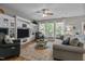 Spacious living room with built-in shelving, a ceiling fan, and large windows with natural light at 648 Long Melford Dr, Rolesville, NC 27571