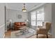Comfortable living room with a leather sofa, patterned chair, and bright natural light at 648 Long Melford Dr, Rolesville, NC 27571
