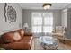 Bright living room with a leather sofa, decorative rug, comfortable armchair, and natural lighting at 648 Long Melford Dr, Rolesville, NC 27571