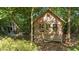 Exterior of a charming wooden shed set among trees with a small porch and double hung windows at 648 Long Melford Dr, Rolesville, NC 27571