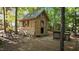 Exterior view of a rustic wooden shed nestled among trees, complete with a workbench at 648 Long Melford Dr, Rolesville, NC 27571