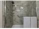 Elegant shower with marbled tile, a hand-held shower head, a built-in shelf, and a grab bar at 648 Long Melford Dr, Rolesville, NC 27571