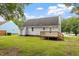 Backyard view featuring a well-maintained lawn, wooden deck, and the rear facade of the house at 71 E Boxley Dr, Wendell, NC 27591