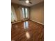 Spacious room with beautiful wood floors, large windows, and a ceiling fan at 710 N Person St # 103, Raleigh, NC 27604