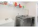 Laundry room with modern appliances, utility sink, and ample shelving at 728 Silo Park Dr, Wake Forest, NC 27587