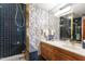 Stylish bathroom features blue tiled shower, wood cabinet vanity, and modern lighting at 812 Kenmore Rd, Chapel Hill, NC 27514