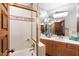 Bathroom features vanity with wood cabinets, white tile shower, and mirrored wall at 812 Kenmore Rd, Chapel Hill, NC 27514
