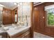 Powder room featuring wood cabinets, decorative wallpaper and lighting and a window to the exterior at 812 Kenmore Rd, Chapel Hill, NC 27514