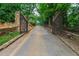 Long, gated driveway leading to a private estate surrounded by lush greenery and mature trees at 812 Kenmore Rd, Chapel Hill, NC 27514