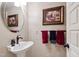 Stylish half-bathroom with modern fixtures, decorative wall art, and a pedestal sink at 812 Kenmore Rd, Chapel Hill, NC 27514