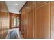 Hallway featuring wood paneling, storage cabinets and a door to the exterior at 812 Kenmore Rd, Chapel Hill, NC 27514