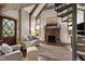 Cozy living space featuring a stone fireplace, plush seating, and ample natural light from surrounding windows at 812 Kenmore Rd, Chapel Hill, NC 27514