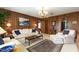 Cozy living room with wood paneled walls, plush seating, and elegant chandelier at 812 Kenmore Rd, Chapel Hill, NC 27514