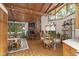 Cozy living room with a stone fireplace, wood-paneled ceiling, and abundant natural light at 812 Kenmore Rd, Chapel Hill, NC 27514