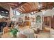 Open-concept living area with wood beamed ceiling, stone fireplace, kitchen, and natural light at 812 Kenmore Rd, Chapel Hill, NC 27514