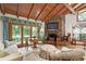 Inviting living room with wood ceiling, stone fireplace, and large windows offering scenic views at 812 Kenmore Rd, Chapel Hill, NC 27514