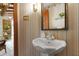 Stylish powder room featuring pedestal sink, decorative wallpaper, and elegant mirror at 812 Kenmore Rd, Chapel Hill, NC 27514