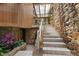 Stairway featuring stone accent walls, tiled steps, wood paneling, and natural light from skylight at 812 Kenmore Rd, Chapel Hill, NC 27514