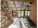 Sunroom with stone wall, tiled floor, wood-paneled wall, and multiple windows for natural light at 812 Kenmore Rd, Chapel Hill, NC 27514