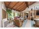 Cozy sunroom with vaulted wood ceilings, windows overlooking the backyard, tile flooring and wicker furniture at 812 Kenmore Rd, Chapel Hill, NC 27514